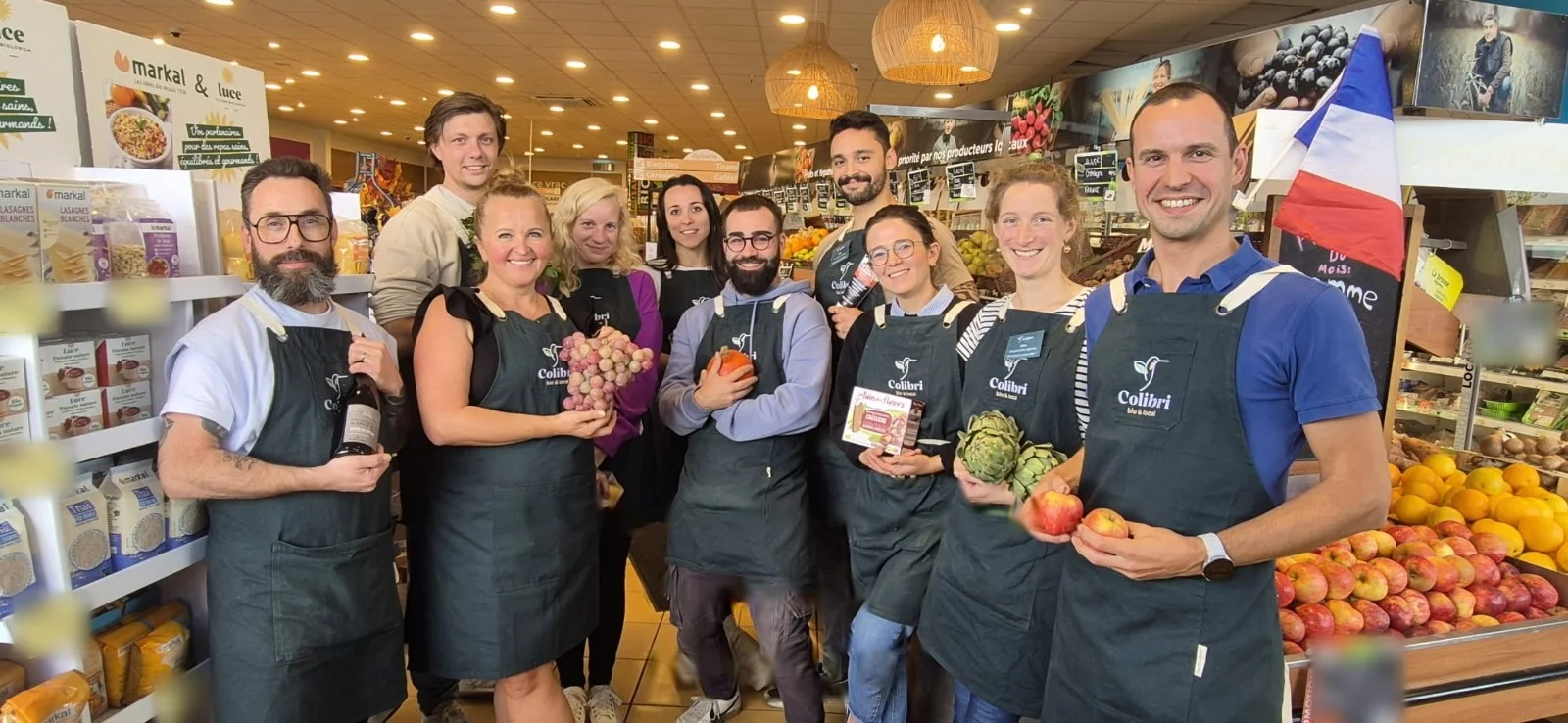 L'équipe Colibri de Puilboreau, en tablier, avec des produits du magasin